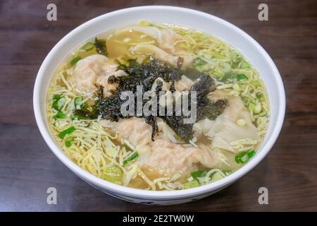 The close up of Taiwanese minced pork wonton noodle soup with seaweed on wooden table at restaurant in Taipei, Taiwan. Stock Photo