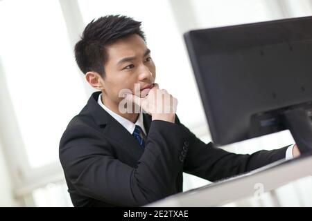 Portrait of businessman sitting at desk,looking at computer,close-up high quality photo Stock Photo
