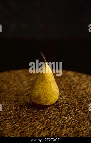 Golden, lonely pear, ripe, very juicy on a black background. Stock Photo