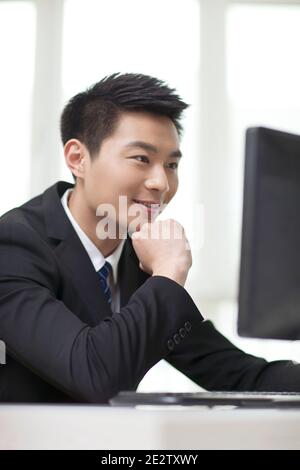 Portrait of businessman sitting at desk,looking at computer,close-up high quality photo Stock Photo