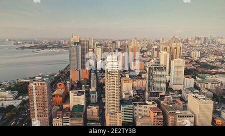 Tropic city cityscape with modern buildings and skyscrapers aerial. Philippines metropolis town of Manila at ocean coast. Beautiful streets and roads. Cinematic scenery at summer sunny day Stock Photo