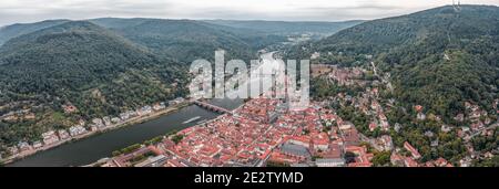 Panoramic aerial drone shot of Heidelberg old town in overcast at foot of Konigstuhl mountain Stock Photo