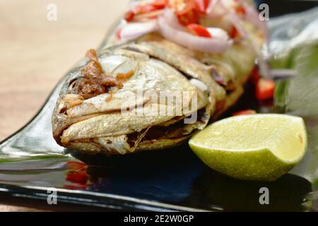 deep grilled mackerel fish topping slice shallot and chili with lemon salad on plate Stock Photo