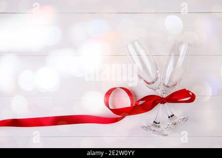 Valentine day concept, wineglass and red ribbon on white wooden table background with bokeh, champaign glass on wood desk, top view, flat lay, couples Stock Photo