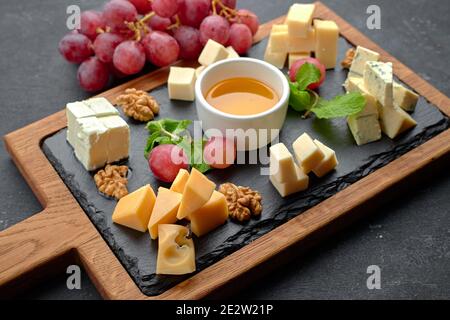 Assorted cheese (cheese board) on a black background Stock Photo