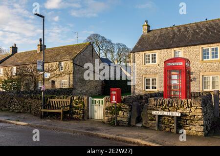 Postbox and telephone kiosk (now repurposed as a book exchange and information point), Monyash, Peak District National Park, Derbyshire Stock Photo