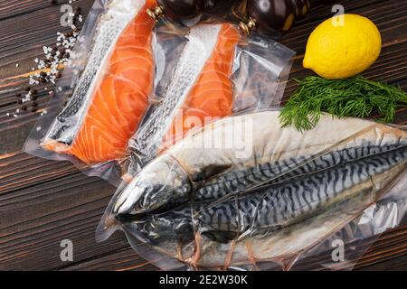 Products in vacuum packaging, on a wooden board. vegetables, fish meat, dolma, kurza. Quarantine Pandemic Stock Photo