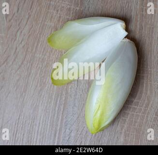Chicory, endive, succory. Witlof vegetable. Fresh leaves chicory on a wooden table Stock Photo