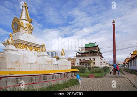 Stupa and Mongolians praying at pole / prayer post in the Gandan / Gandantegchinlen Monastery in the capital city Ulaanbaatar / Ulan Bator, Mongolia Stock Photo