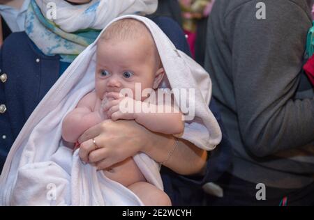 Little girl in towel after baptism ceremony. Stock Photo