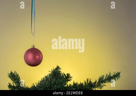 New Year card with Xmas toys and fir branch. A gradient from gray to yellow is used as the background. Stock Photo