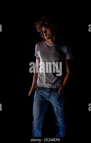 Teenager boy with afro hairstyle isolated on a black background Stock Photo