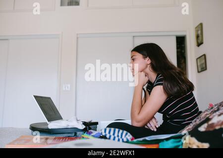 Profile Of A Tween Girl On Her Laptop During Online School Stock Photo