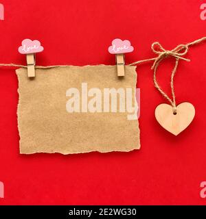 Valentines day mockup. Craft paper on the rope, wooden heart. Stock Photo