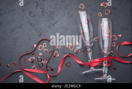 Valentine's day greeting card with champagne glasses and candy hearts on stone background. Top view with space for your greetings. Flat lay