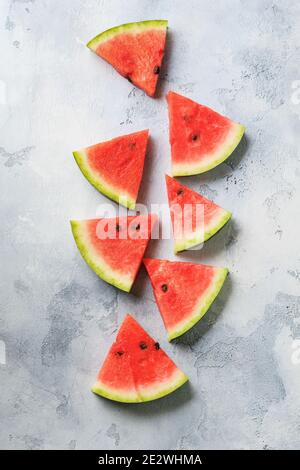 Slices of fresh watermelon with ice on a blue concrete background. Detox and vegetarian concept. Top view, copy space, banner Stock Photo