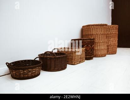 Row of handmade natural wicker baskets with handle and cap, storage Stock Photo
