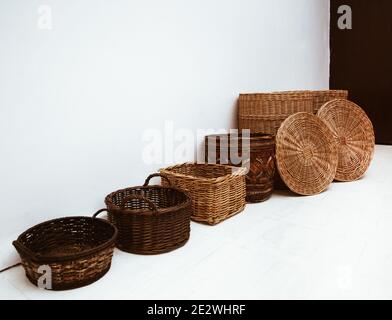 Many wicker straw and bamboo baskets in row with handle and cap Stock Photo