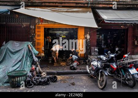 Two Men work on Refurbishing Auto Parts at Small Shop in Talat Noi Stock Photo