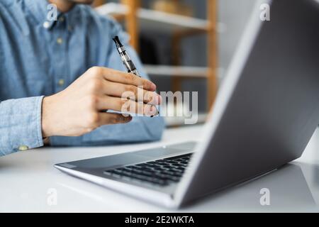 Virtual Smoking Break Using Electronic Cigarettes And Video Conference Stock Photo