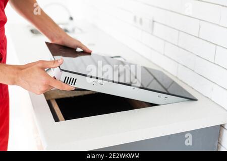Installation of induction stove or cooktop by a master. Stock Photo
