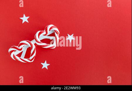 Carnival glasses with heart-shaped frames on a red background with space for text. Stock Photo