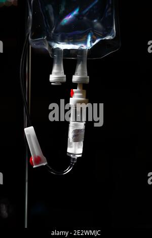 Medical drip bag on the dark background. Stock Photo