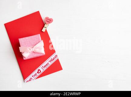 Red envelope and gift box with a bow on a white background with space for text. Stock Photo
