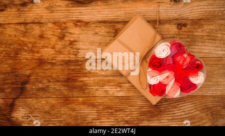 Letters in craft paper envelopes and a gift of roses on a wooden background Stock Photo
