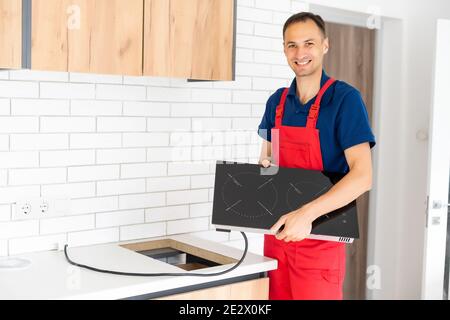 Young service contractor assembling kitchen furniture Stock Photo