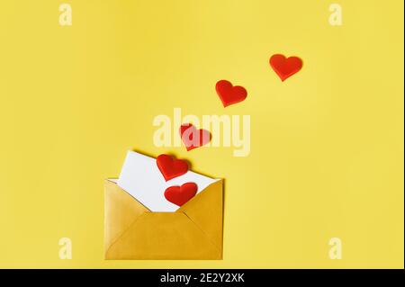 An opened golden envelope with hearts and love letter inside. Saint Valentine Day concept Stock Photo