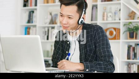young man  wear headset and using video conference  on laptop computer at home Stock Photo