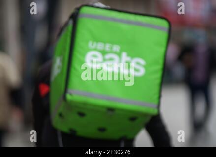 Bucharest, Romania - November 12, 2020: Attention! Intentionally blurred image. An Uber Eats food delivery courier delivers food in Bucharest, Romania Stock Photo