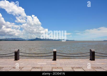 Shenzhen bay park and walkway along the waters edge. The Shenzhen bay bridge to Hong Kong is in the distance. Stock Photo