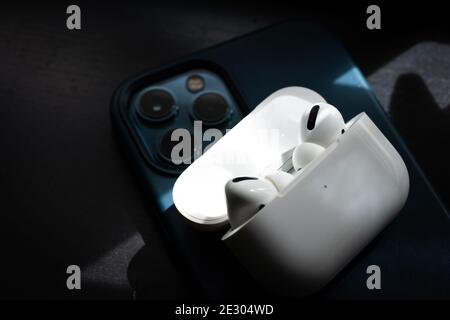 Apple Airpods Pro isolated on wooden surface. The new airpods pro features active noise cancelling and customizable fit Stock Photo