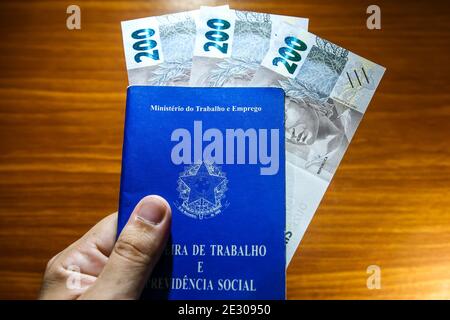 Sorocaba, Brazil. 15th Jan, 2021. Work card and three 200 reais bills. With the end of the emergency aid of 600 reais in January 2021, about 48 million Brazilians were impacted. Approximately R $ 275 billion was paid in 2020 to 68 million people. Credit: Cadu Rolim/FotoArena/Alamy Live News Stock Photo