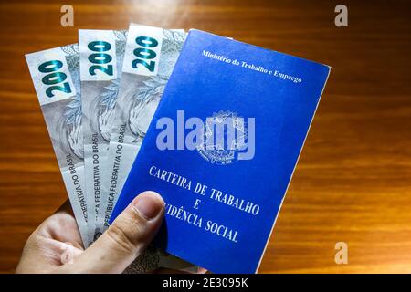 Sorocaba, Brazil. 15th Jan, 2021. Hand holding three 200 reais bills and business card. With the end of the emergency aid of 600 reais in January 2021, about 48 million Brazilians were impacted. Approximately R $ 275 billion was paid in 2020 to 68 million people. Credit: Cadu Rolim/FotoArena/Alamy Live News Stock Photo