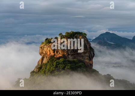 The sunrise of Sigiriya Rock in Sri Lanka from a view on Pidurangala Temple in Sri Lanka. It is the best time to hike up there in the morning. Stock Photo