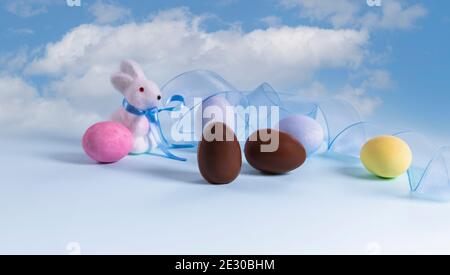 Painted eggs, chocolate eggs and cute bunny figurine Stock Photo