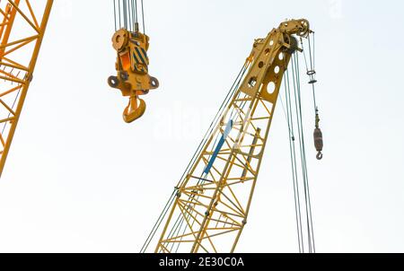 Crawler crane isolated on white background. Real estate industry. Yellow crawler crane use reel lift up equipment in construction site. Crane for rent Stock Photo