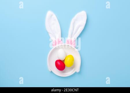 Creative Easter composition. Easter eggs and bunny ears on blue background. Copy space - Image Stock Photo