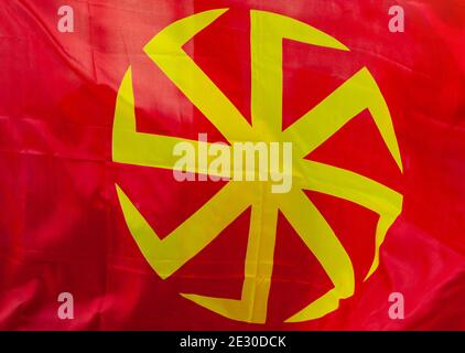 Yellow eight-pointed swastika - Kolovrat on a red background. Stock Photo