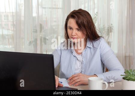 Business woman working at home with a laptop. Remote, home office, remote work concept - Image Stock Photo