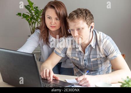 Two programmers, man and woman working from home, remote, home office. Remote work concept - Image Stock Photo