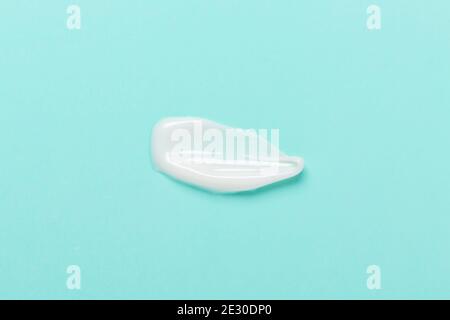 Cosmetic clay mask for face and body. White texture on blue background. Close-up - Image Stock Photo