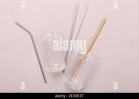 Zero waste, plastic free concept. Glass cup, metal and bamboo straw. Flat lay on textile linen background - Image Stock Photo