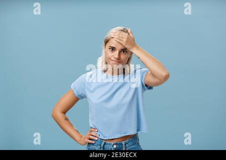 Girl cannot deal with naughty kids being left alone while mom on shopping holding hand on forehead breathing out losing temper being in troublesome Stock Photo