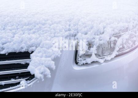 Car headlight in the snow. Frozen car on snowy day Stock Photo