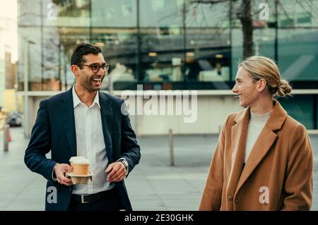 Mixed race colleagues laughing together forming relationships while enjoying fresh coffee Stock Photo
