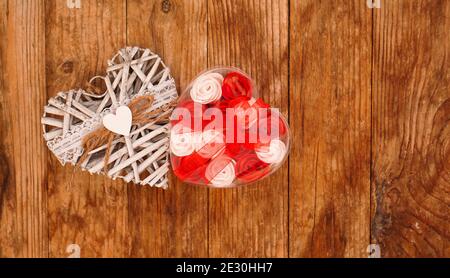 Red and white roses and Valentine day white heart on wooden background. Top view with copy space Stock Photo